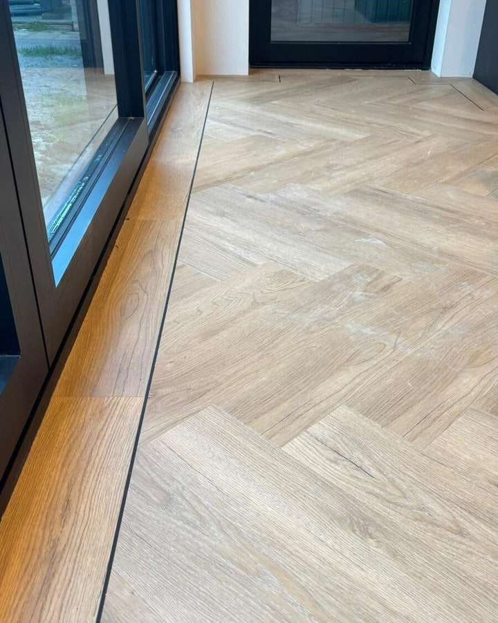 Een visgraatvloer met bies langs de pui